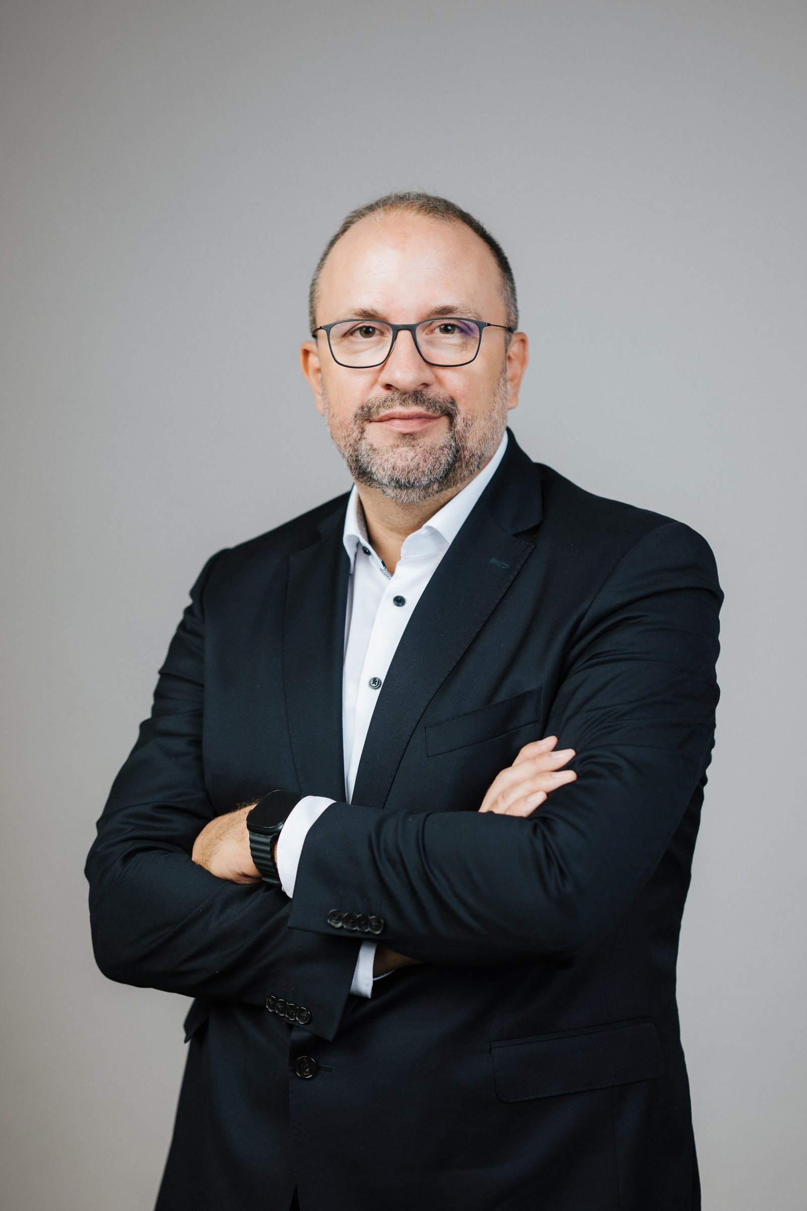 Rechtsanwalt Matthias Biskupek mit verschränkten Armen vor grauem Hintergrund