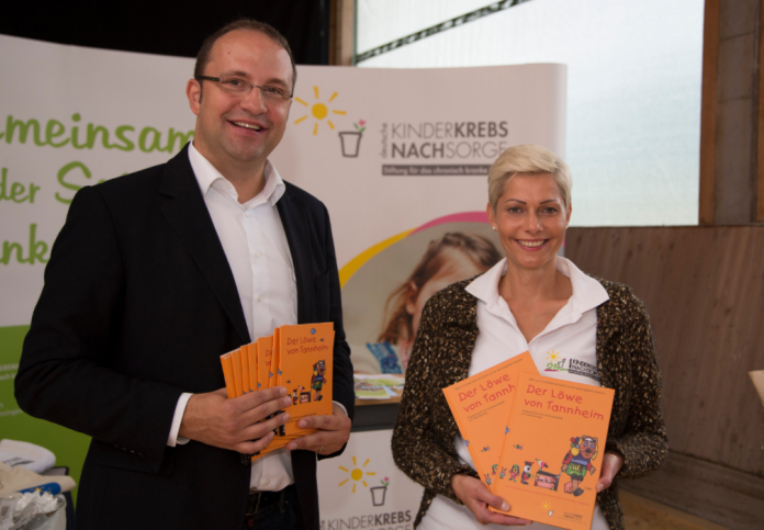 Matthias Biskupek mit dem Buch „Der Löwe von Tannheim“ am Stand der Deutschen Kinderkrebsnachsorge